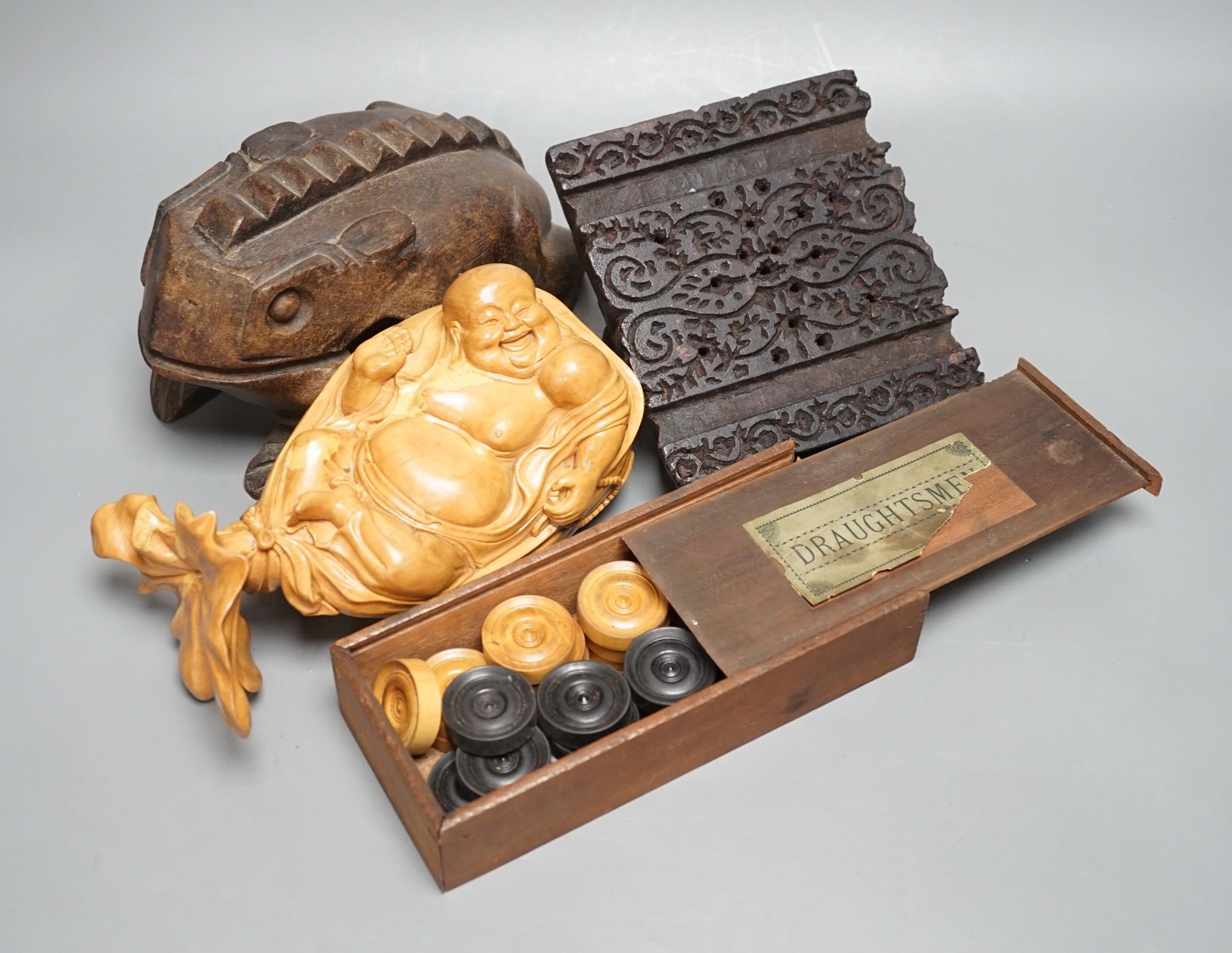 A Chinese carved wood frog, 22cm long, a carved Buddha, woodblock and a part-set of draughtsmen